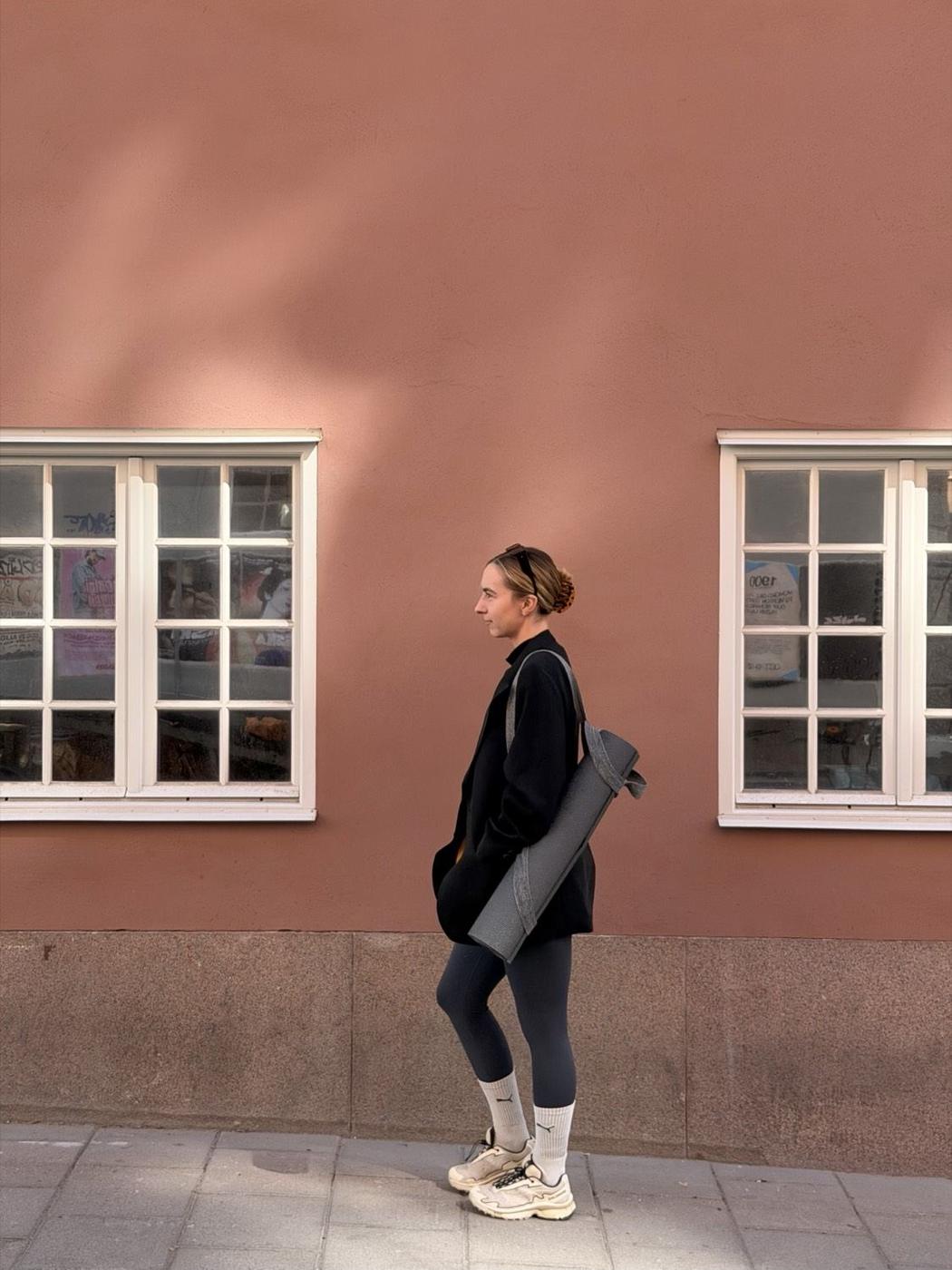 Camilla, a yoga teacher in Stockholm, walking with a yoga mat